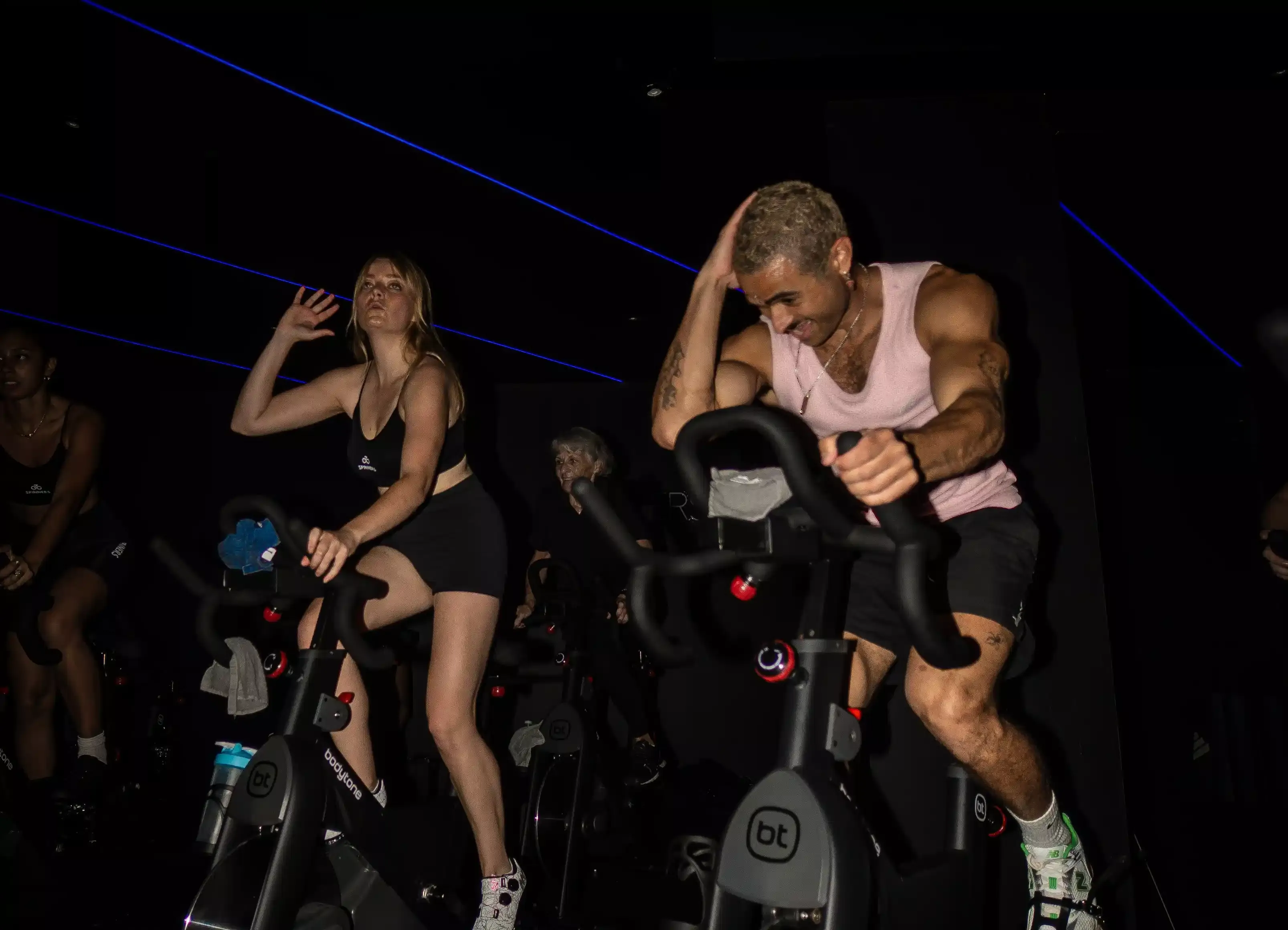 Une participante pédale sous les lumières du studio Spinners Cycling à Toulouse